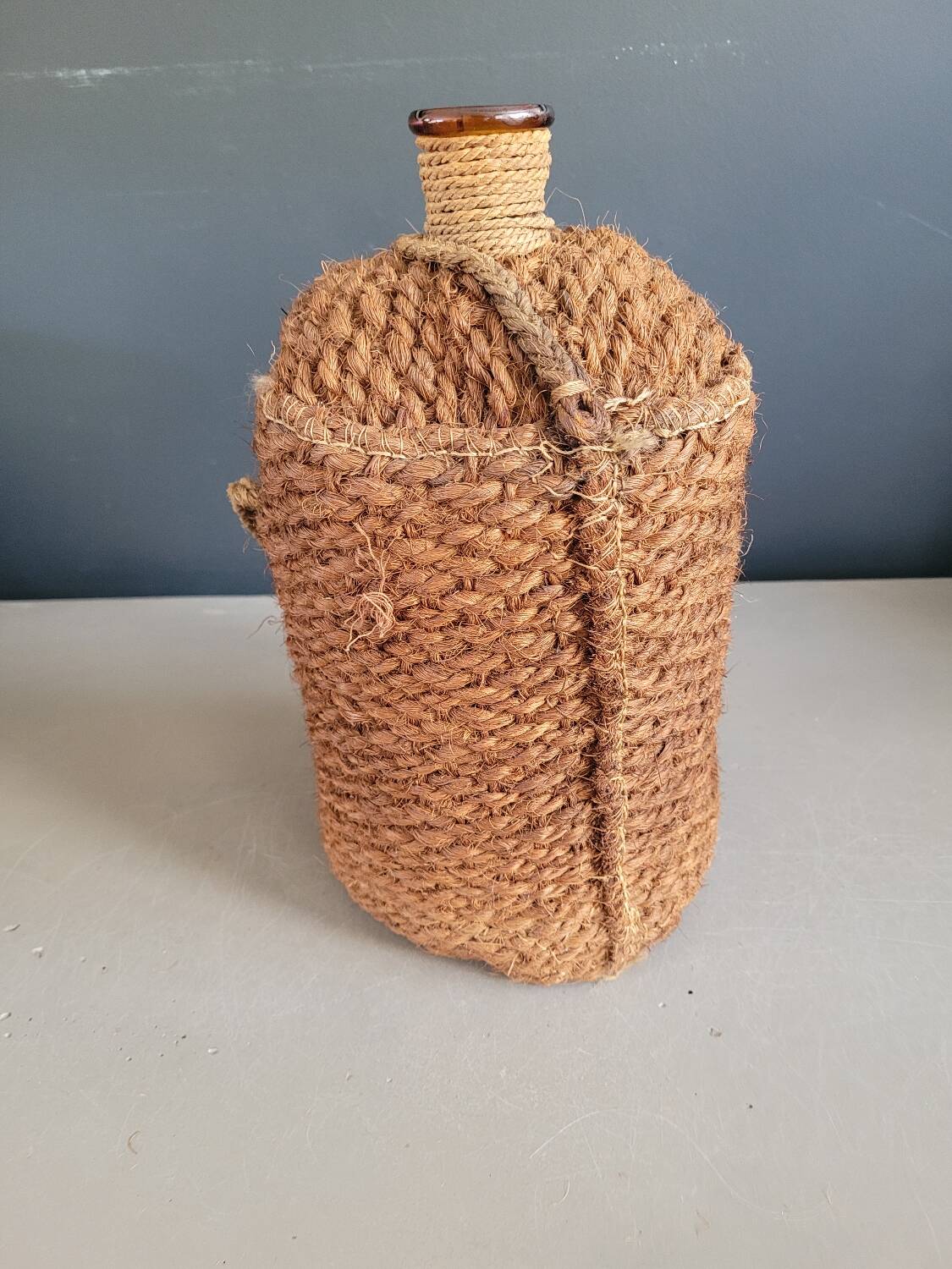 Antique amber glass bottle and hemp carrying bag