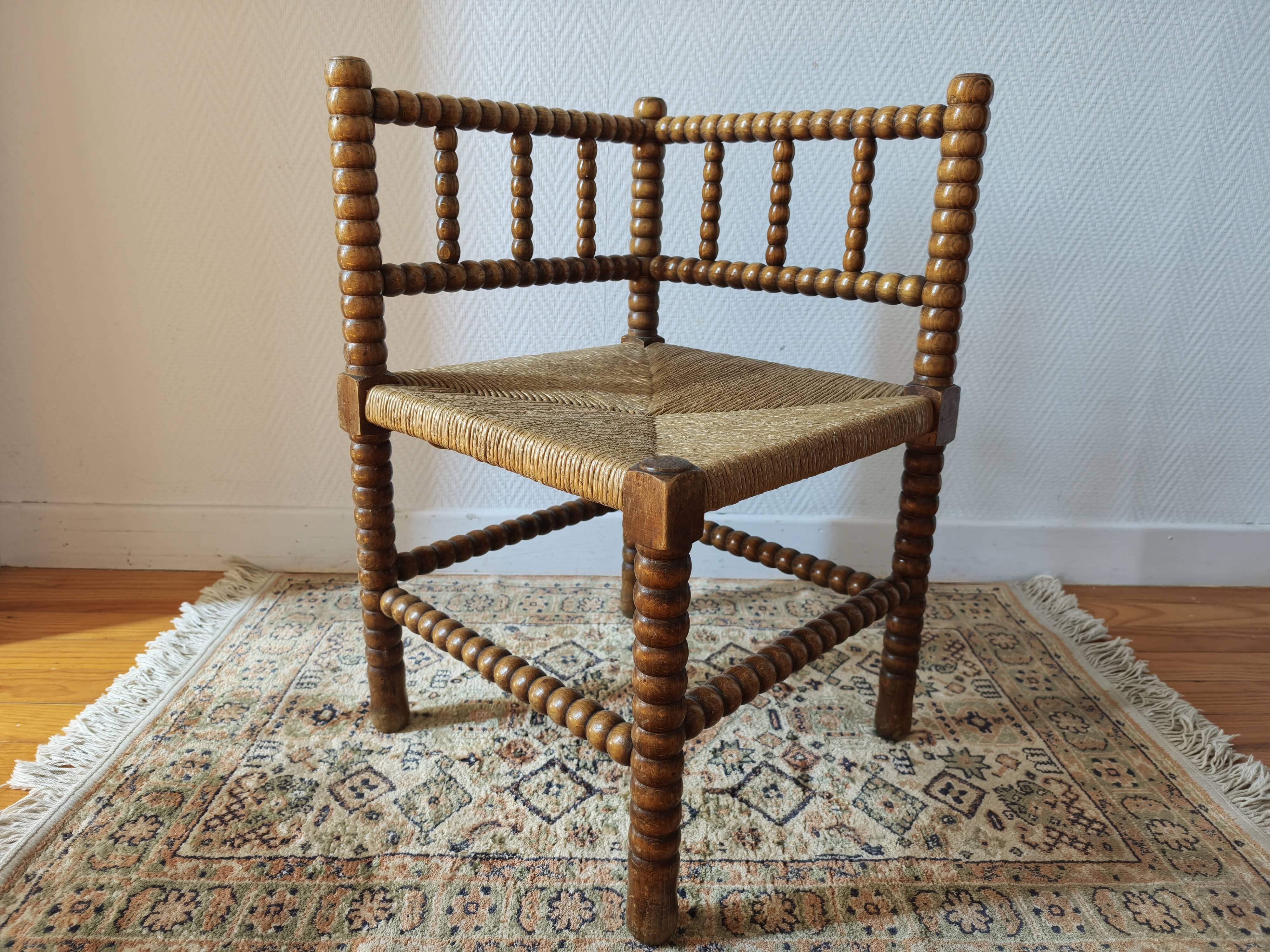 Antique corner chair by the fire with turned wood and straw seat.