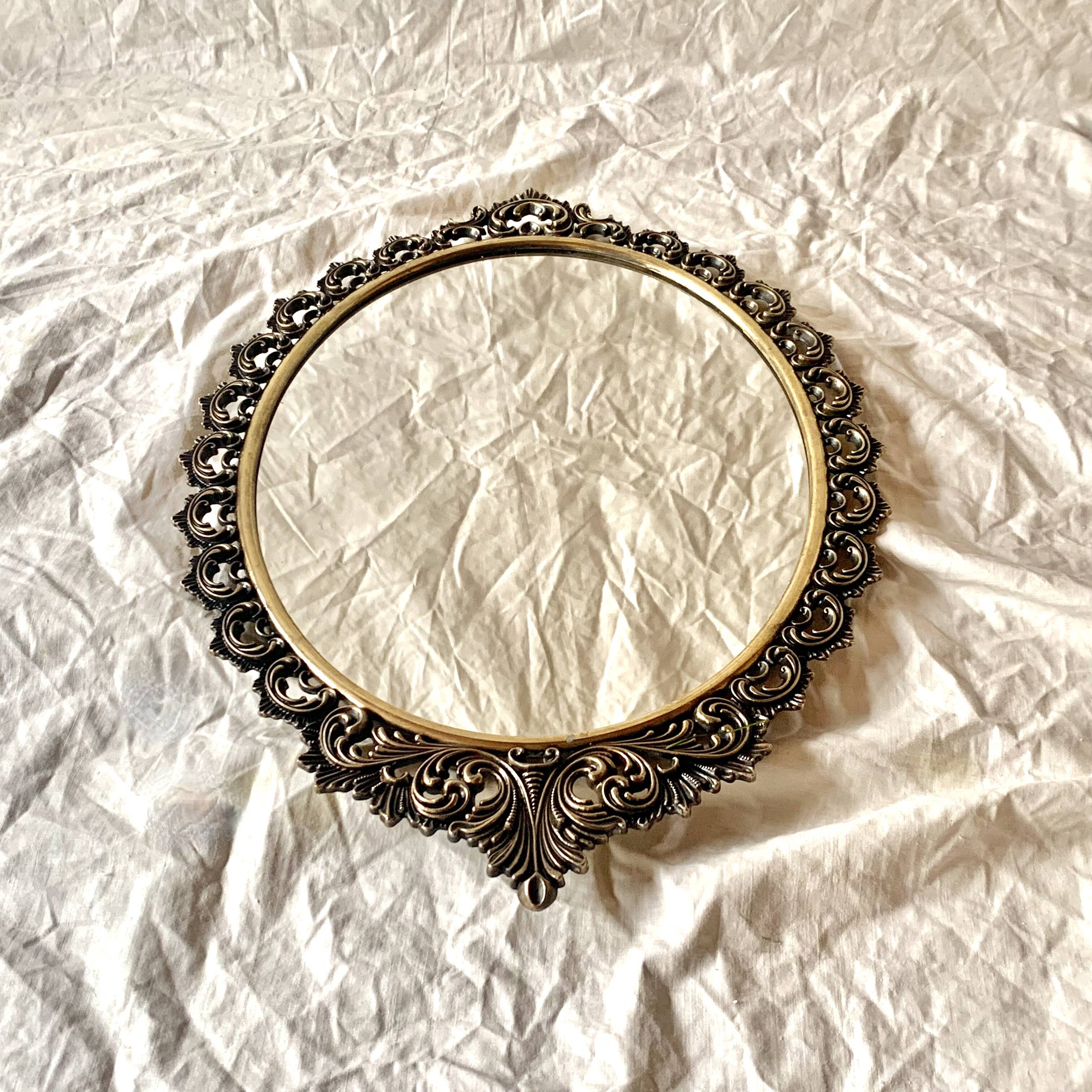 Old oval wall mirror in gilded brass