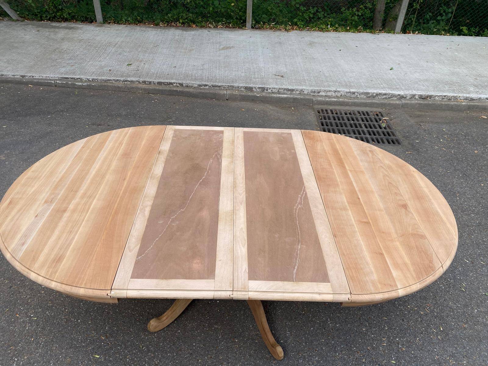 Round dining table with a central pedestal, extendable, stripped in solid walnut with 2 extensions.