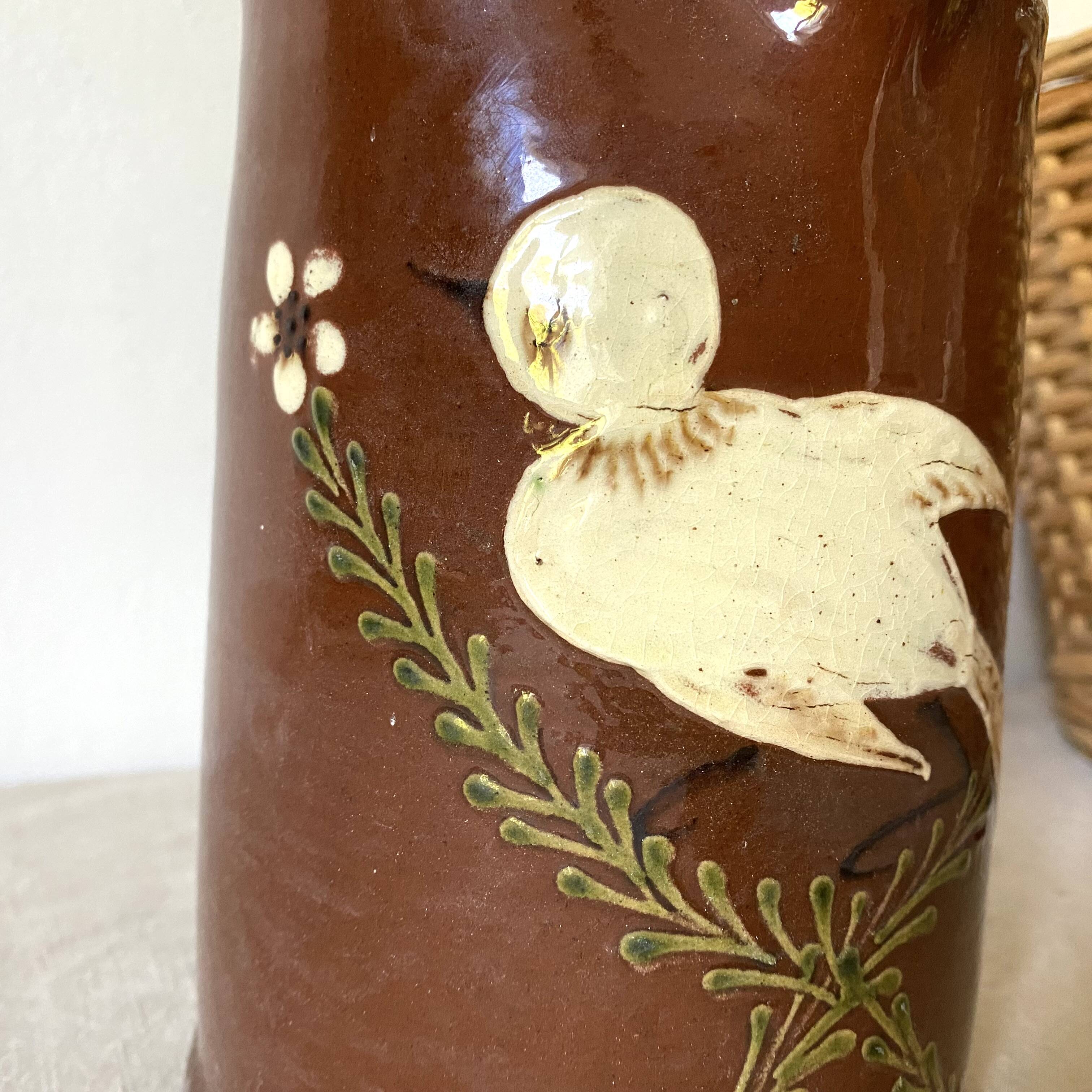 Terracotta pitcher with hand-painted bird decor