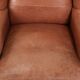 Fauteuil anglais à oreilles de couleur cognac clair en cuir de vache.