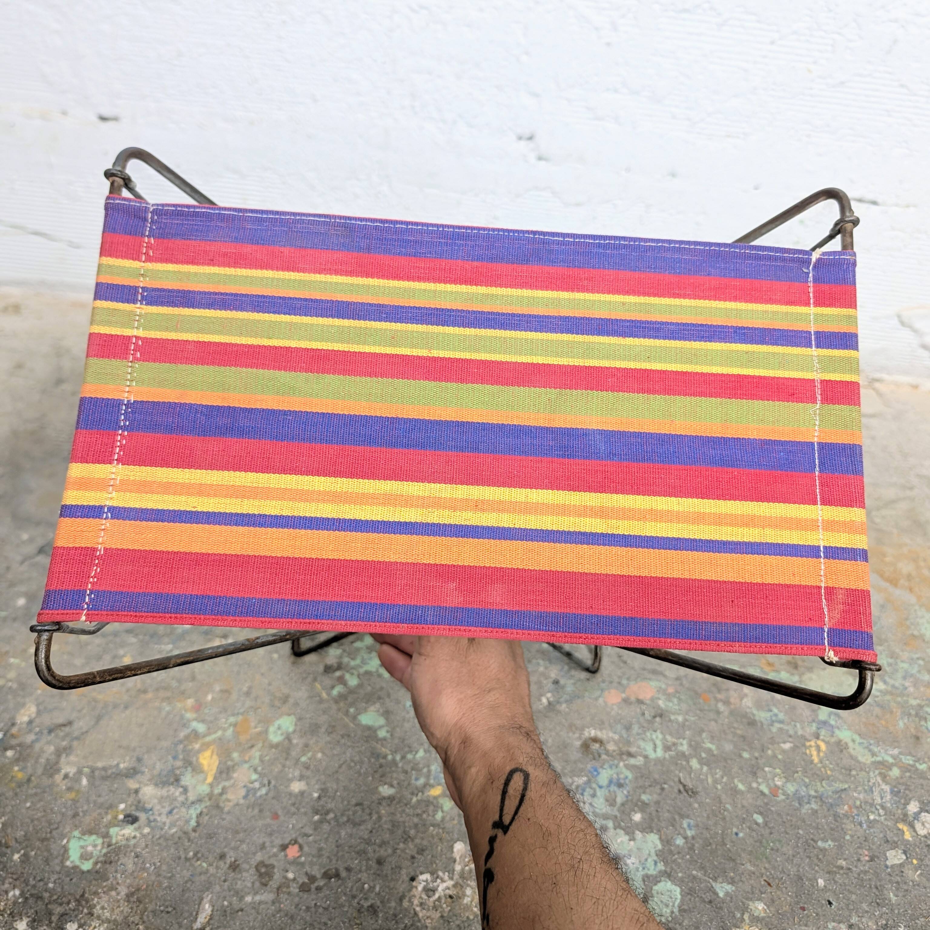 Vintage folding stool with a bayadère fabric pattern.