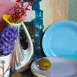 Seven pastel-colored plates mixed with vintage earthenware