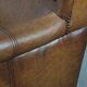 Cognac-coloured wingback armchair in English style made of cowhide leather