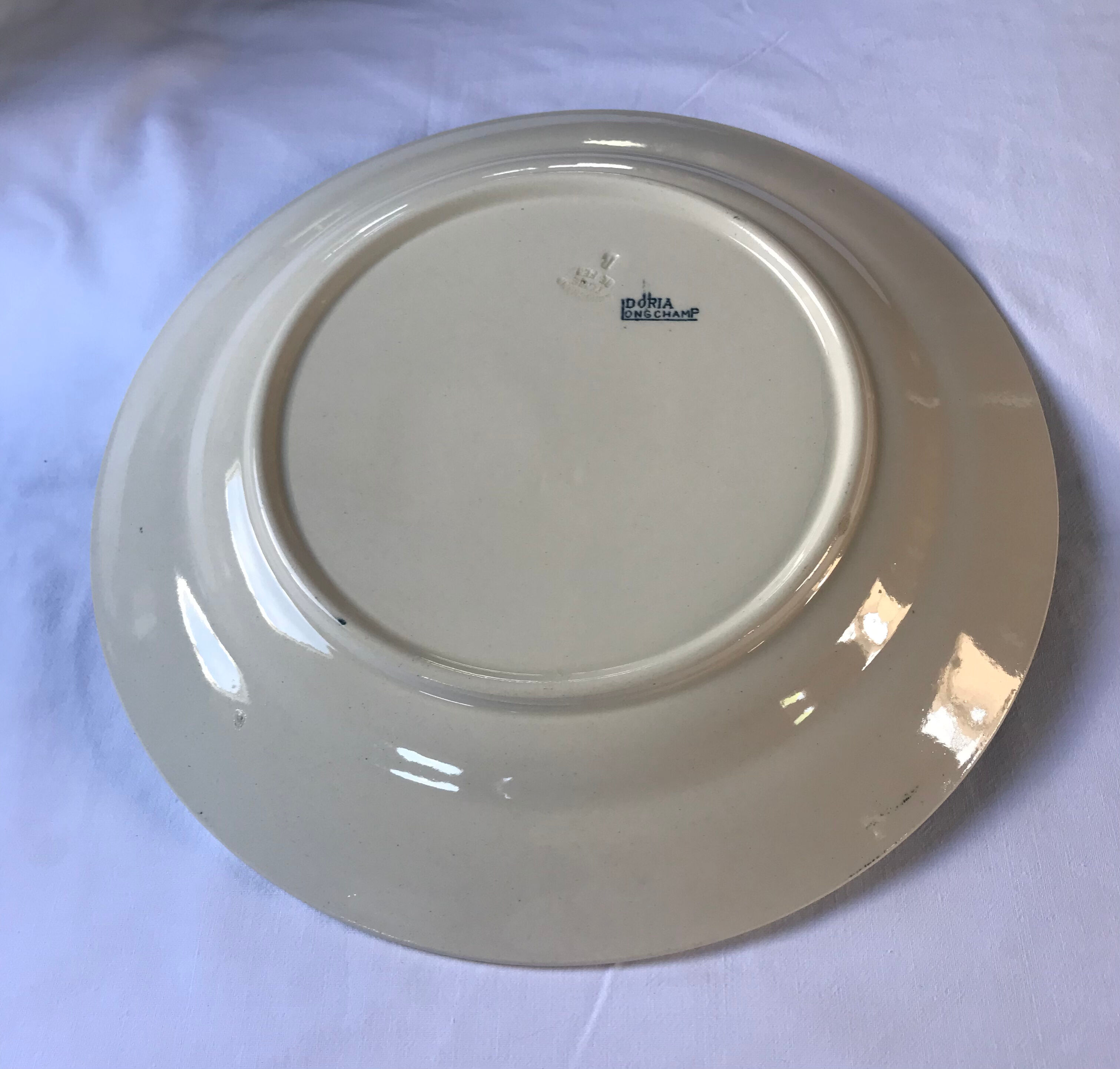 Round serving dish from the Longchamp earthenware factory, Doria model. Iron Land