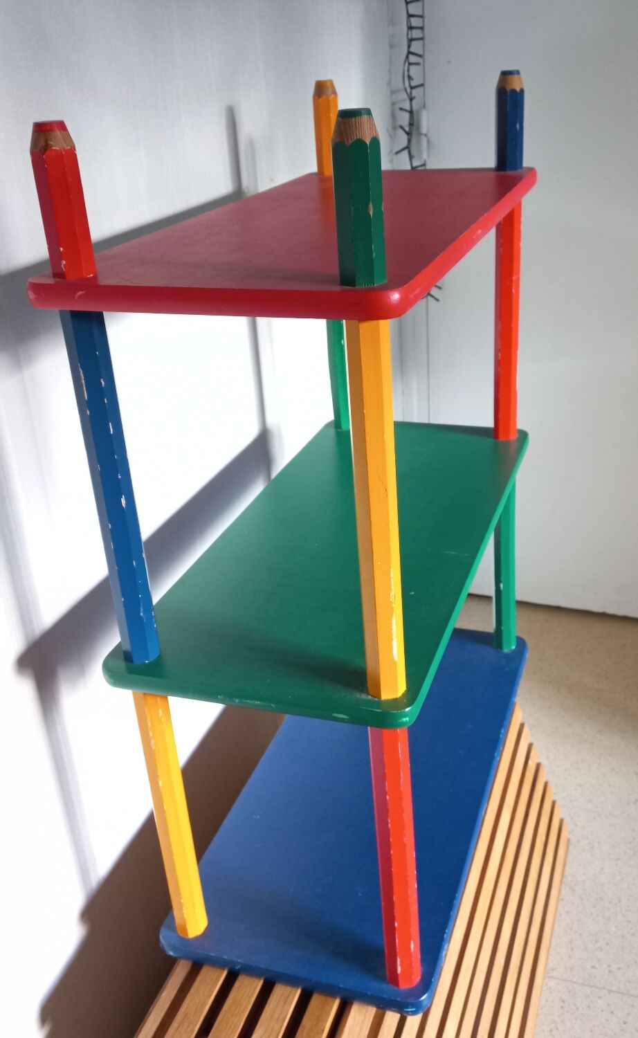 Shelf on legs, library, crayons in 4 colours.