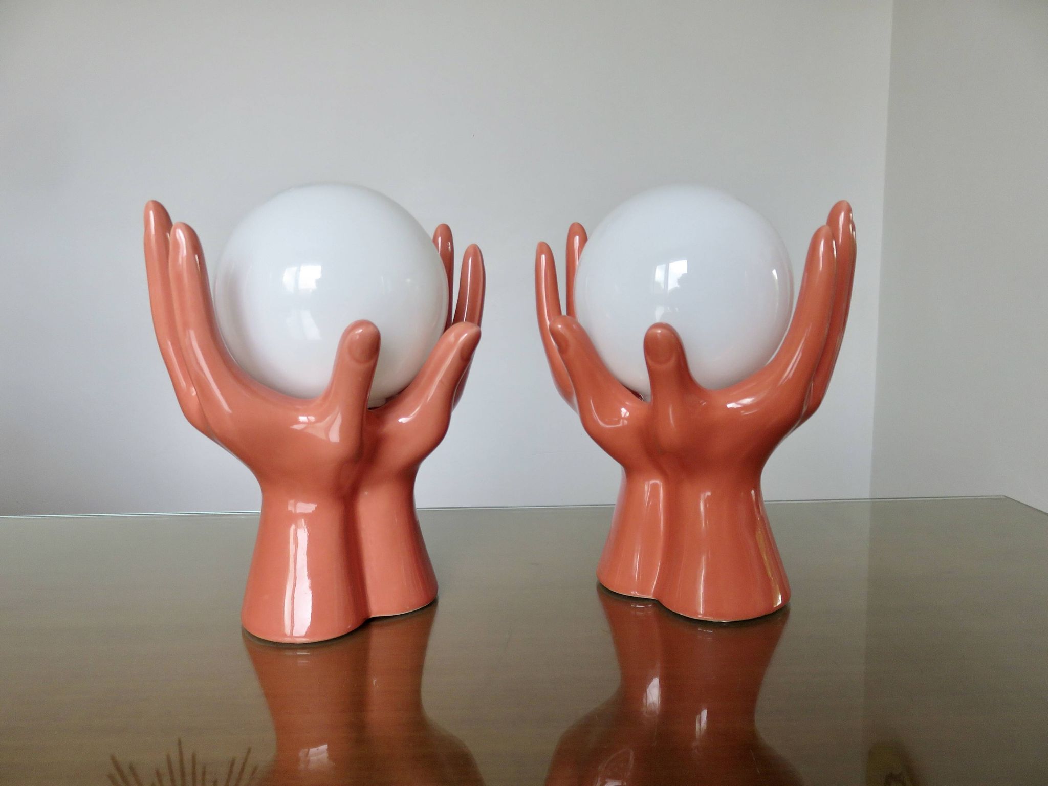Pair of salmon-colored ceramic "hand" lamps with opaline globe, 80