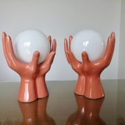 Pair of salmon-colored ceramic "hand" lamps with opaline globe, 80