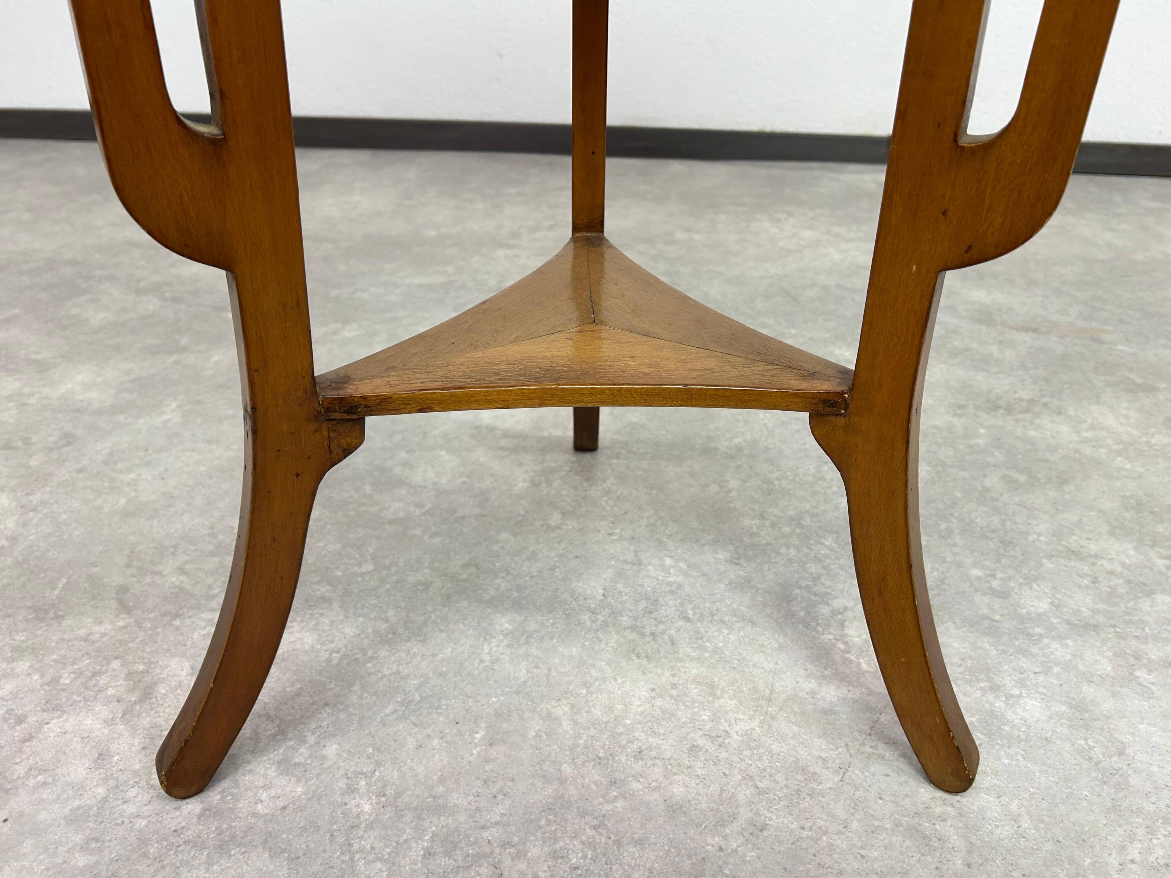 Round Art Nouveau coffee table with a sculpted top.