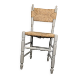 Rustic chair made of turned wood and straw.