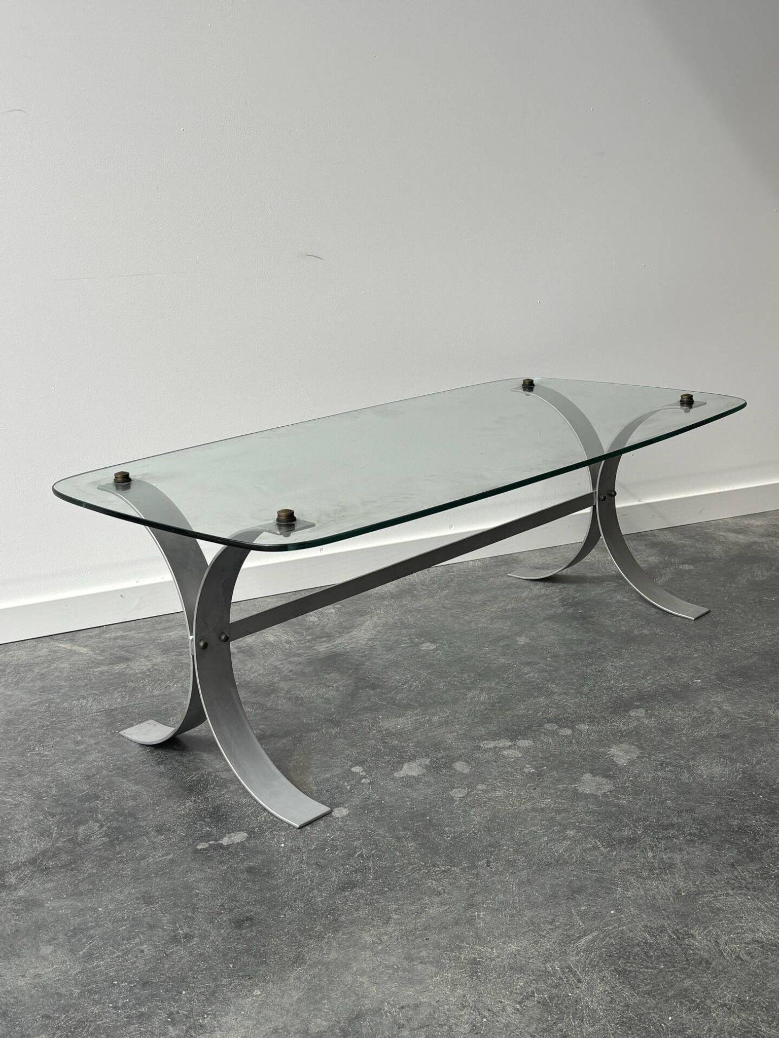 Design coffee table in brushed metal with a glass top, 1970s.