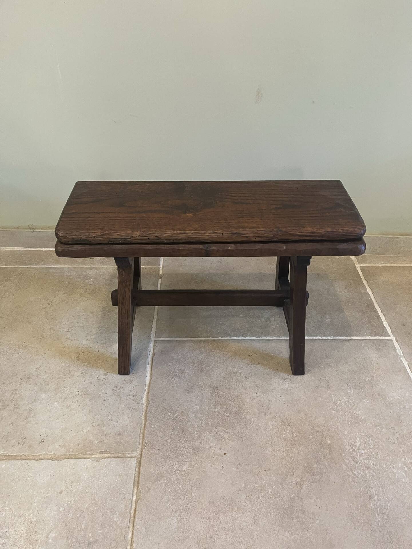 Small antique wooden bench with a folding backrest.