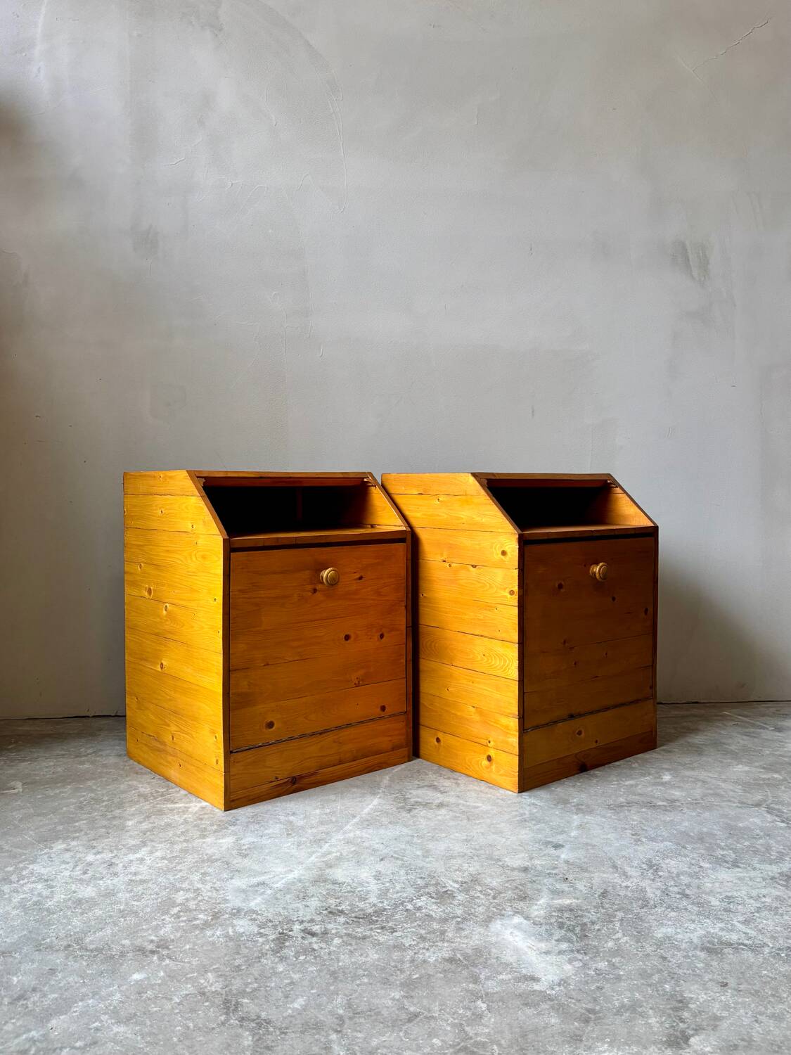 Pair of handcrafted solid wood bedside tables with drop-down doors.