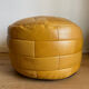 2 poufs moutarde patchwork en cuir de Sède