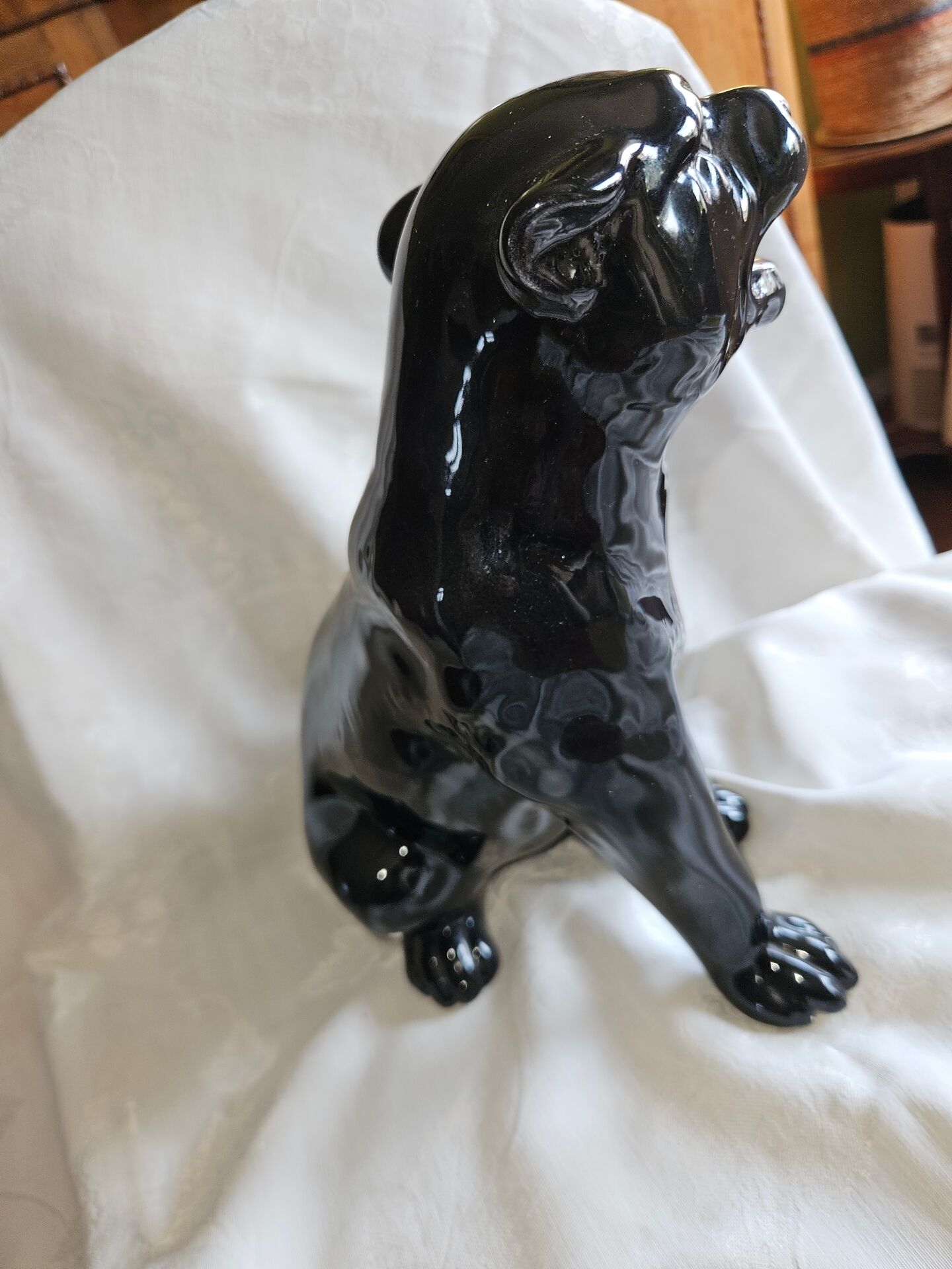 Statue of a roaring panther/leopard sitting in black glazed ceramic.