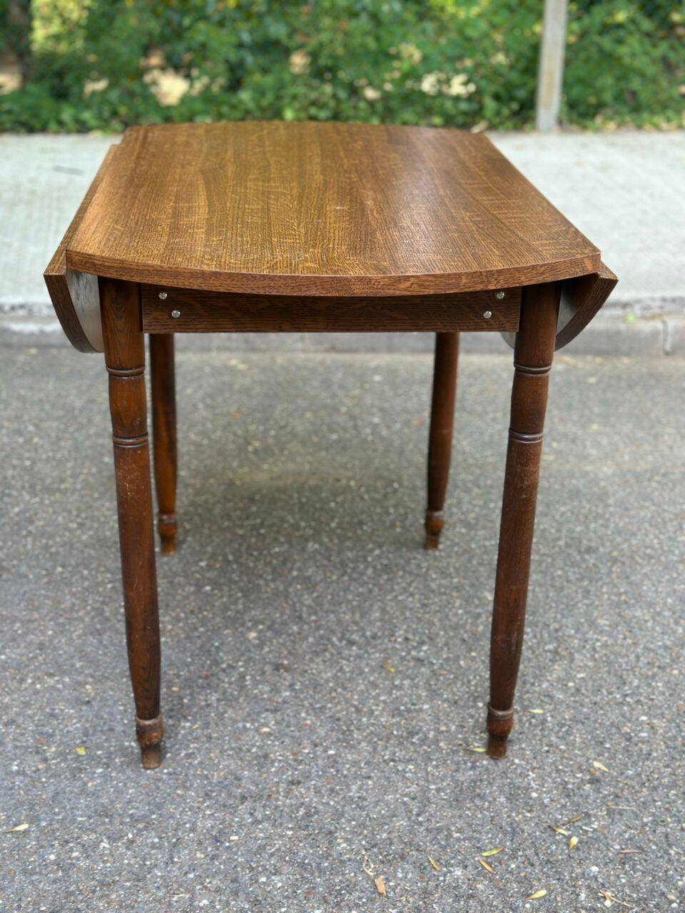 Round kitchen table with extendable leaves in dark wood.