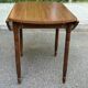 Round kitchen table with extendable leaves in dark wood.