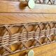 Vintage wooden and rattan chest of drawers with tapered legs.