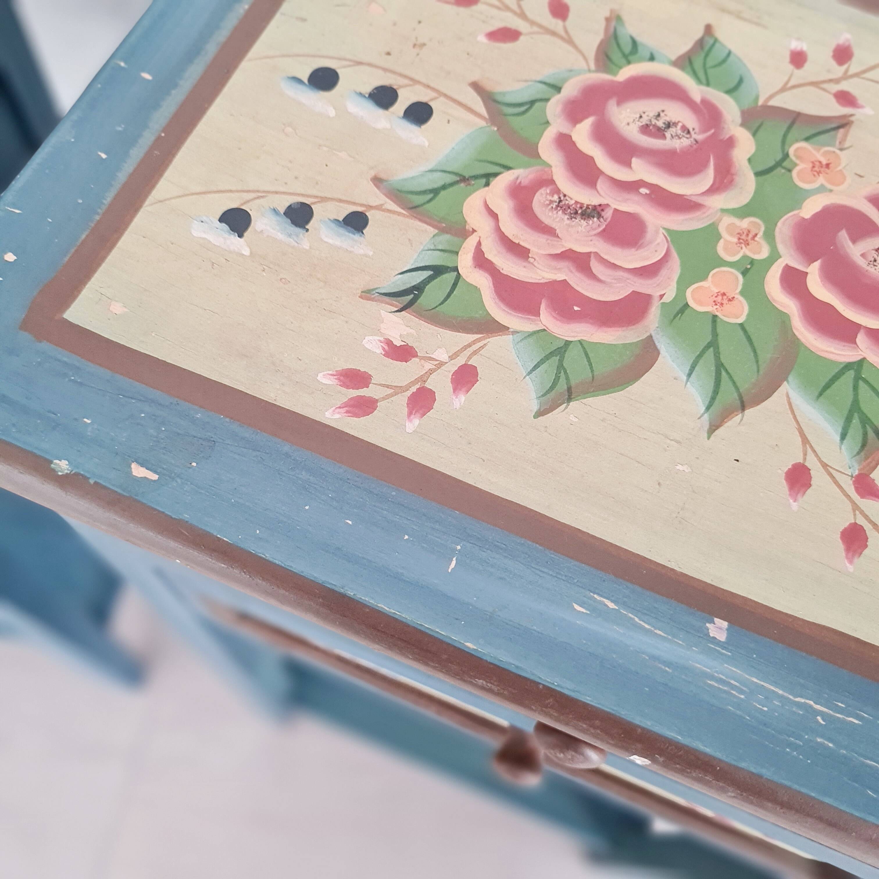 Blue wooden bedside tables with floral patterns