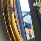 Oval-shaped gilded wooden mirror