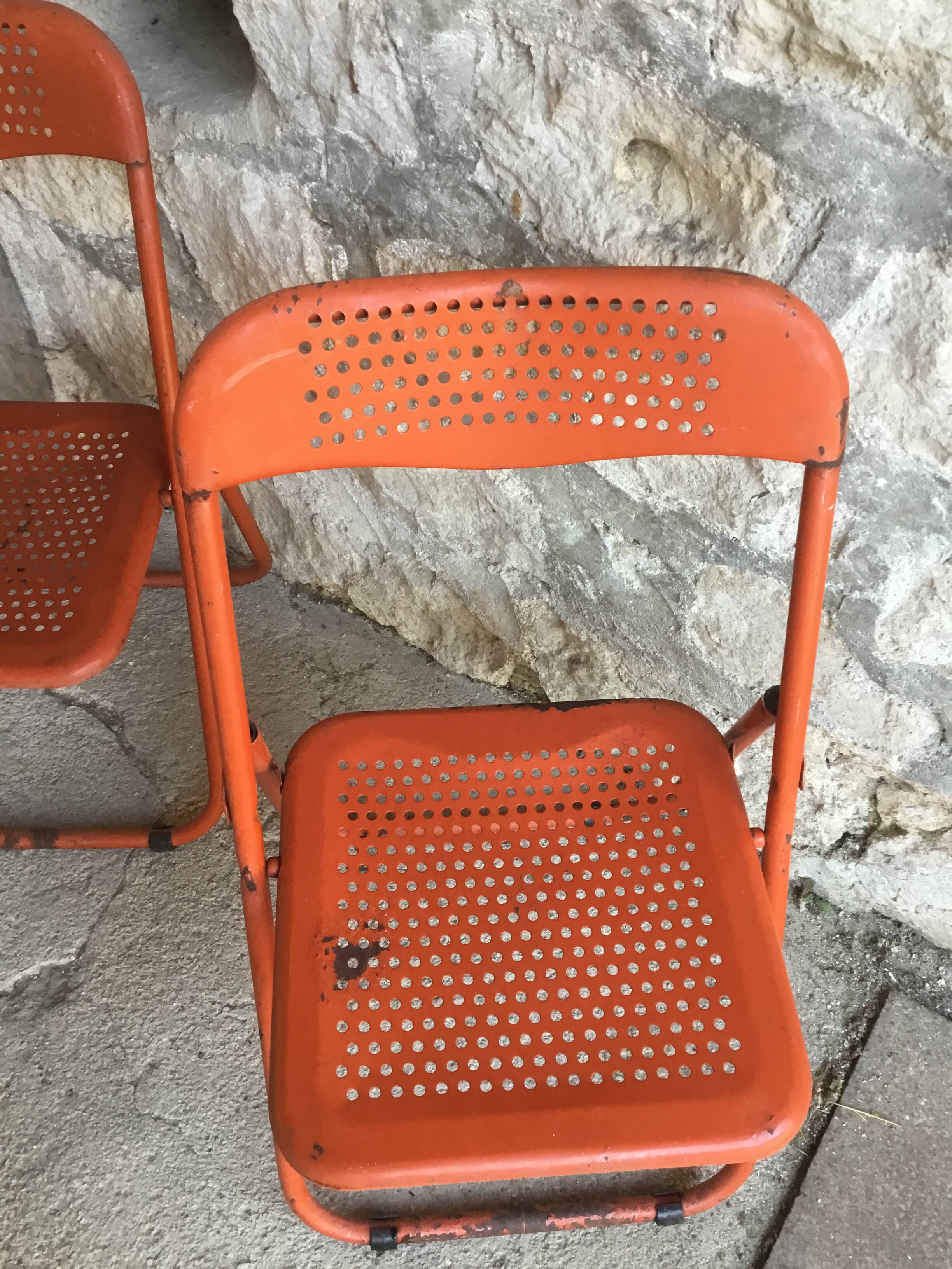 Trio of orange metal folding chairs - vintage