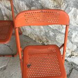 Trio of orange metal folding chairs - vintage