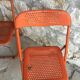 Trio of orange metal folding chairs - vintage