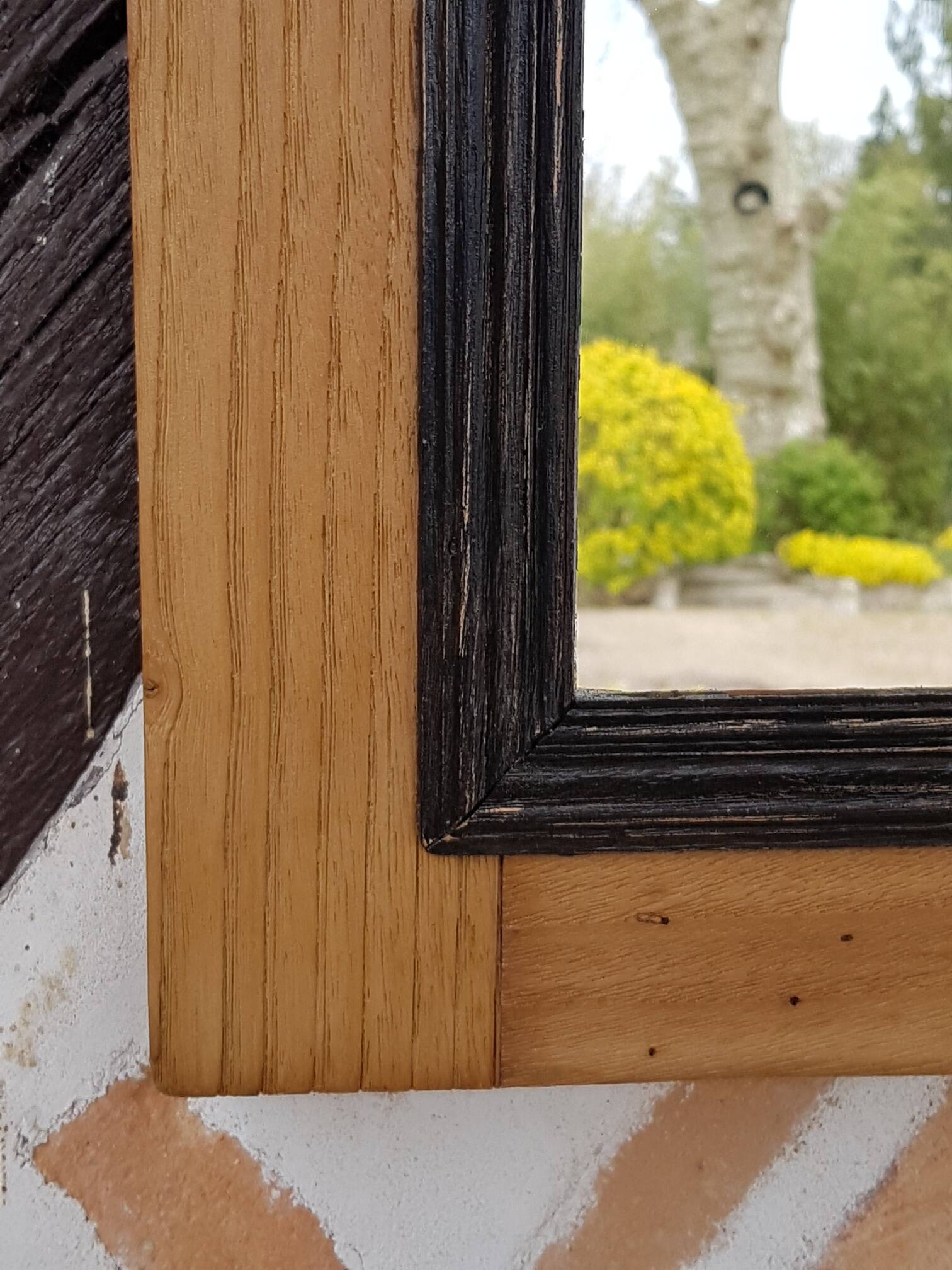 Black mirror and raw natural wood