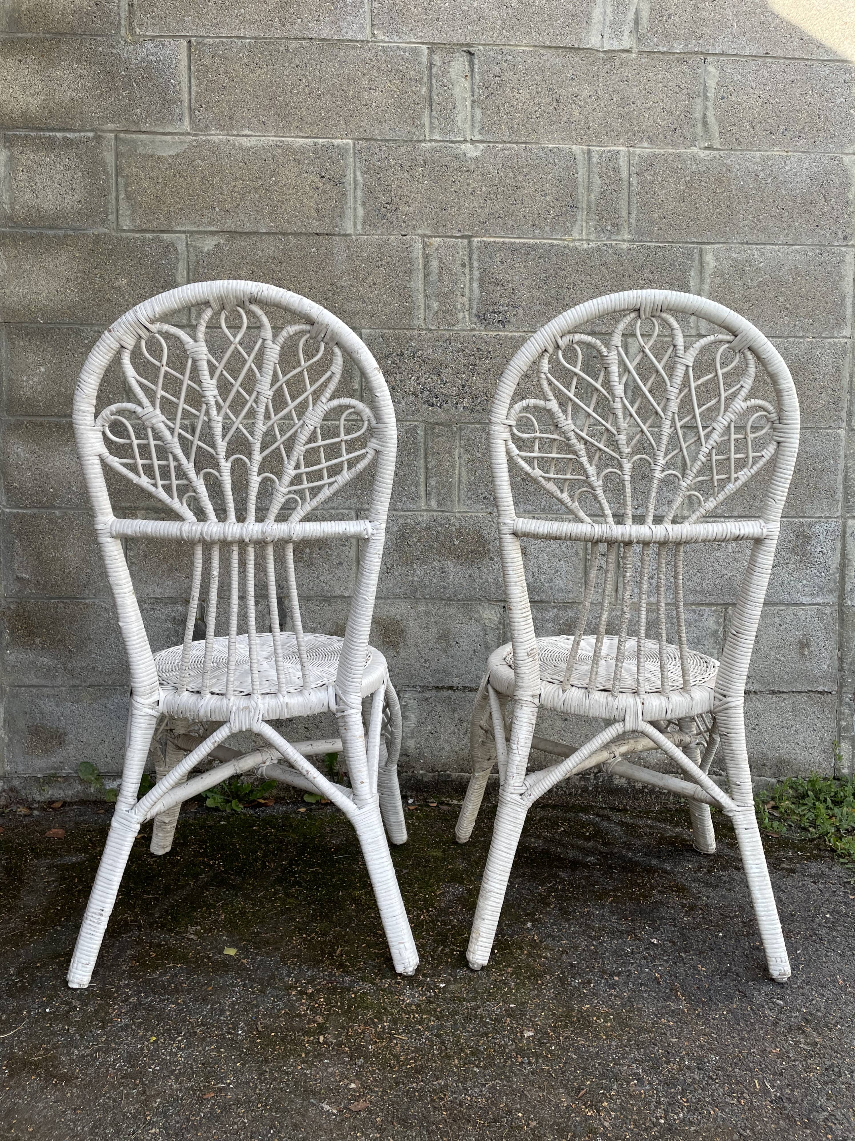Pair of white peacock rattan chairs, circa 1960