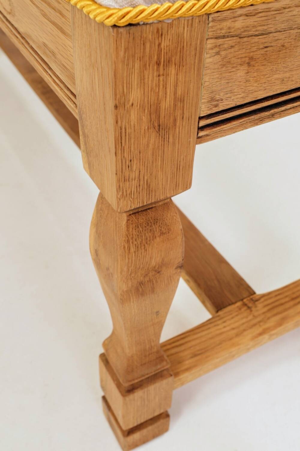 Vintage oak bench with striped linen fabric in a country style.