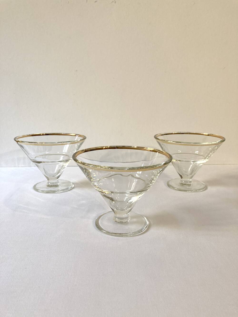 Trio of glass dessert bowls with gold rims, La Rochère, France