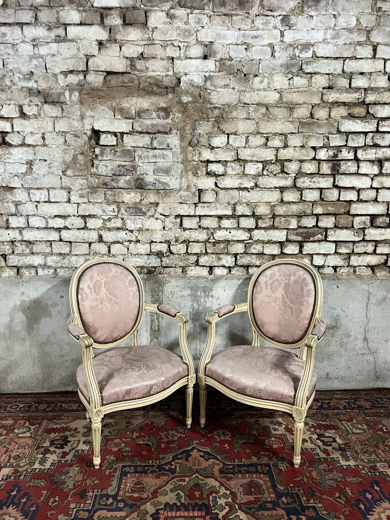 Paire de fauteuils dossier médaillon en bois laqué crème de style louis xvi