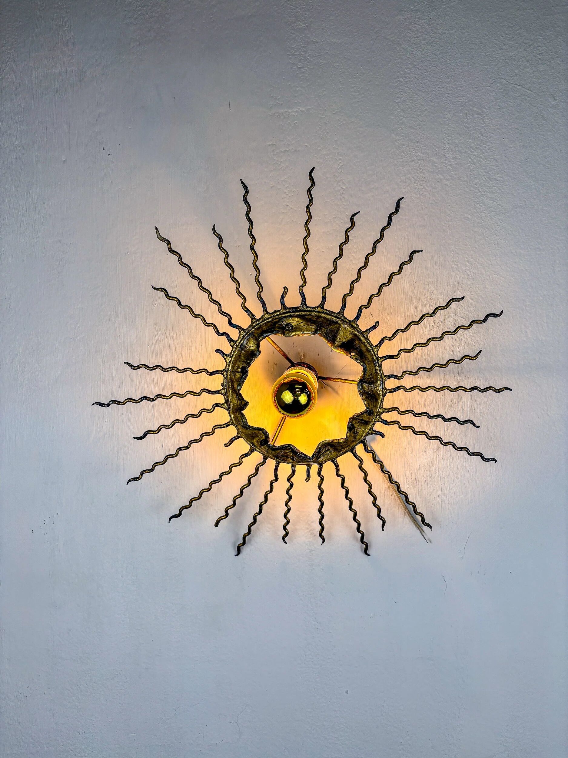 Spanish sunburst ceiling light – gilt iron rays & exposed bulb, 1960s