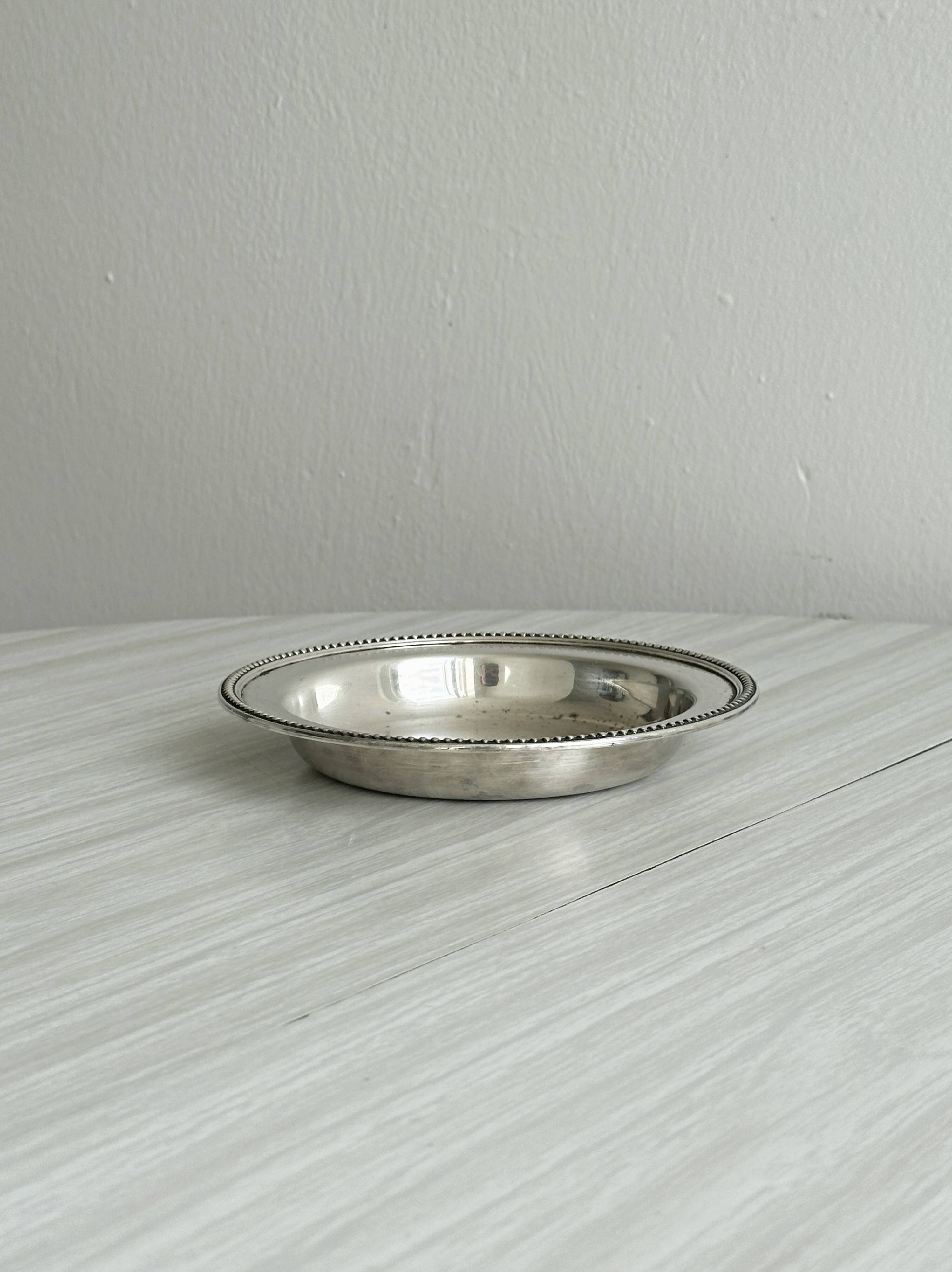 Round patinated silver-plated metal dish
