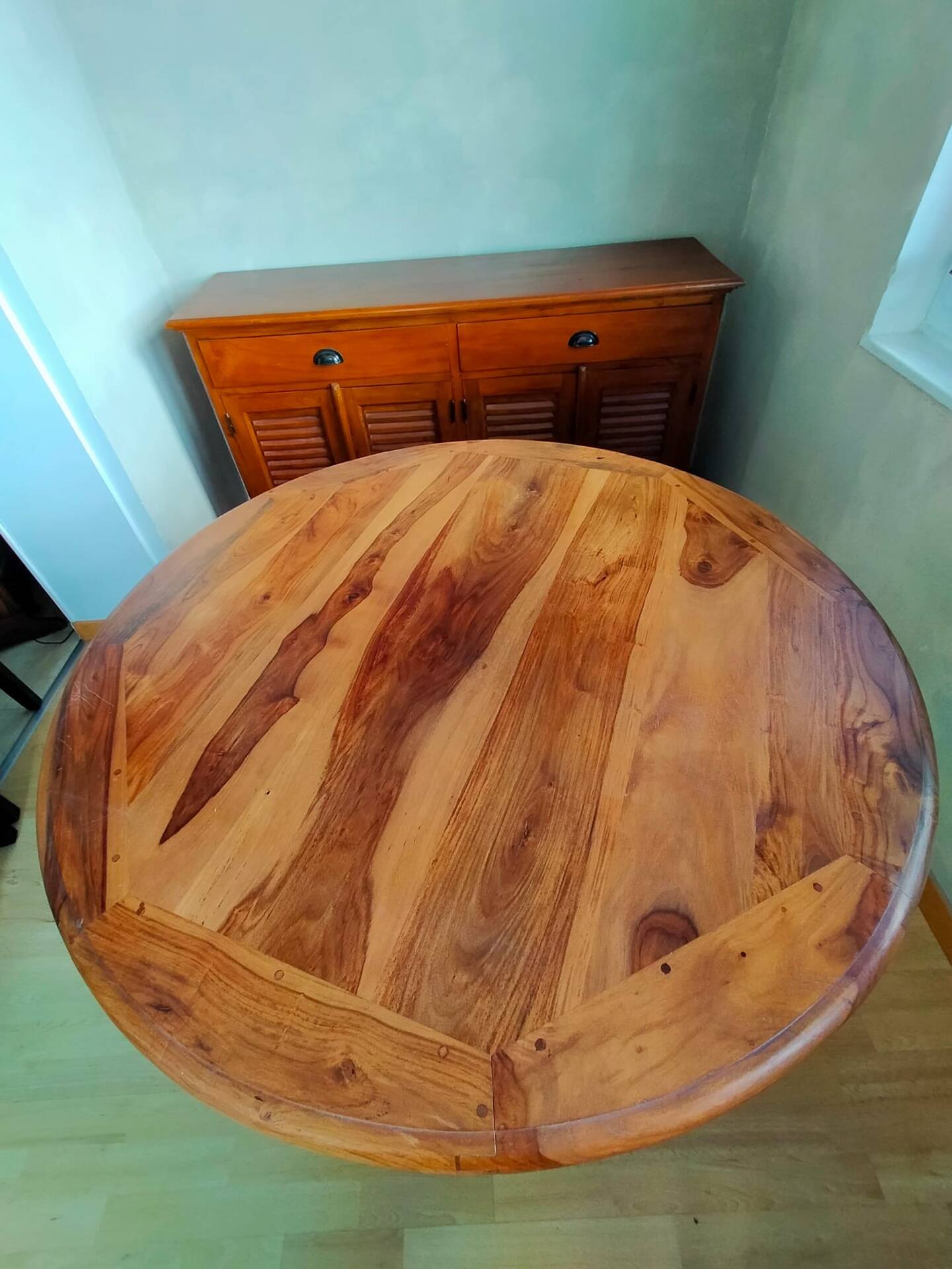 Round wooden table with wrought iron legs.