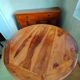 Round wooden table with wrought iron legs.