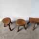 Set of three rustic solid wood tripod stools.