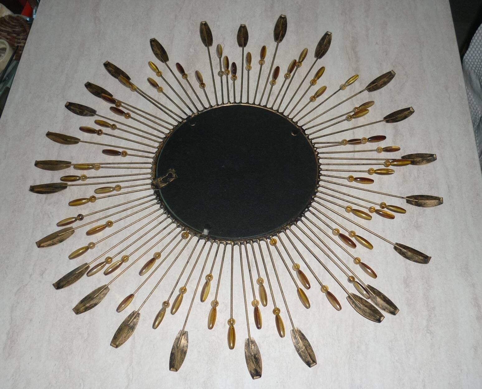 Round sun mirror with pearl rays and leaves