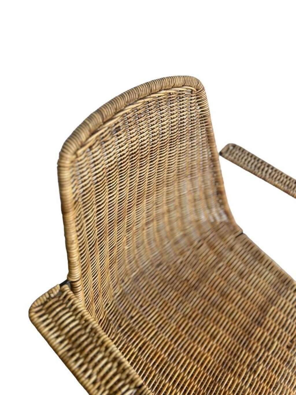 Vintage wicker chair with black steel frame and armrests