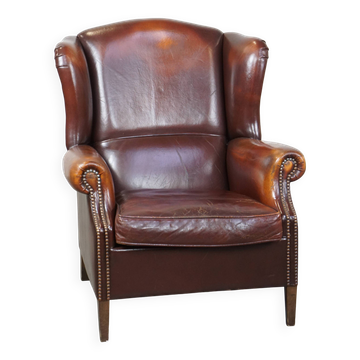 Dark English style sheepskin wingback chair with character and patina