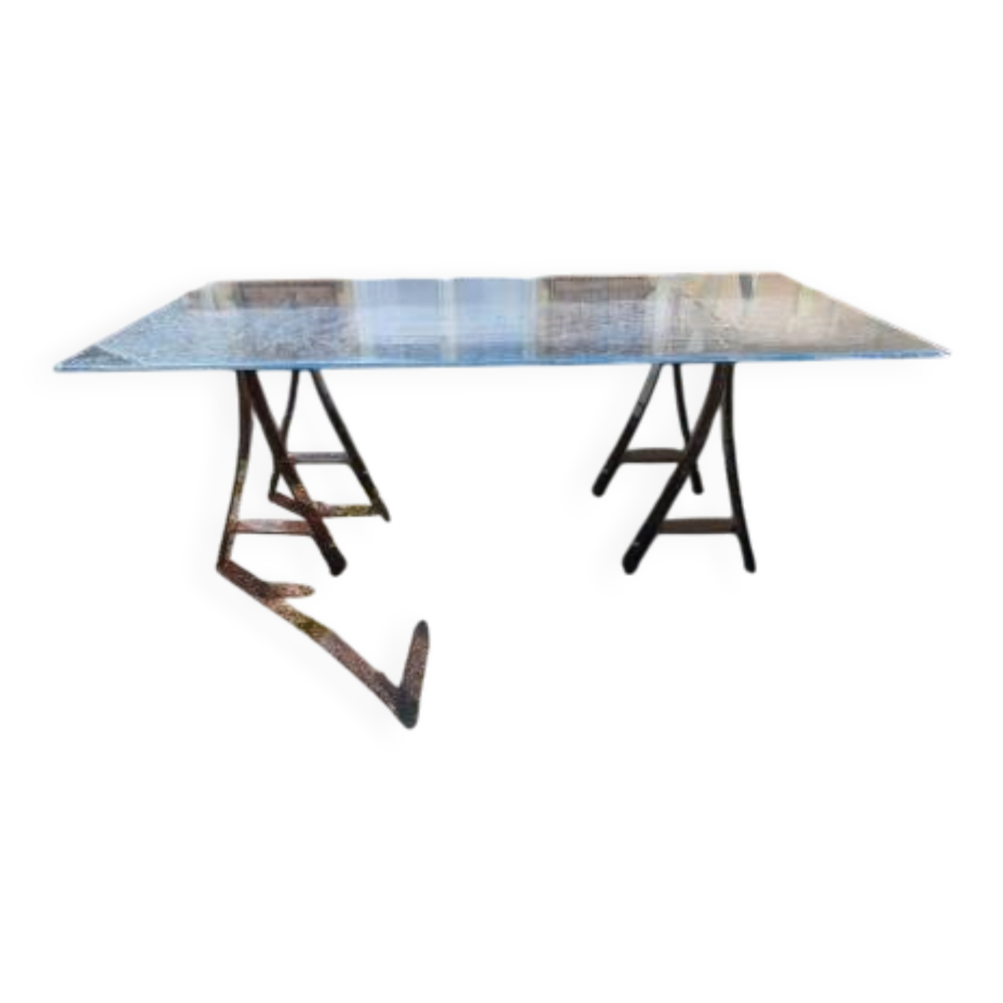 Vintage table with a glass top and smoked plastic trestle legs.