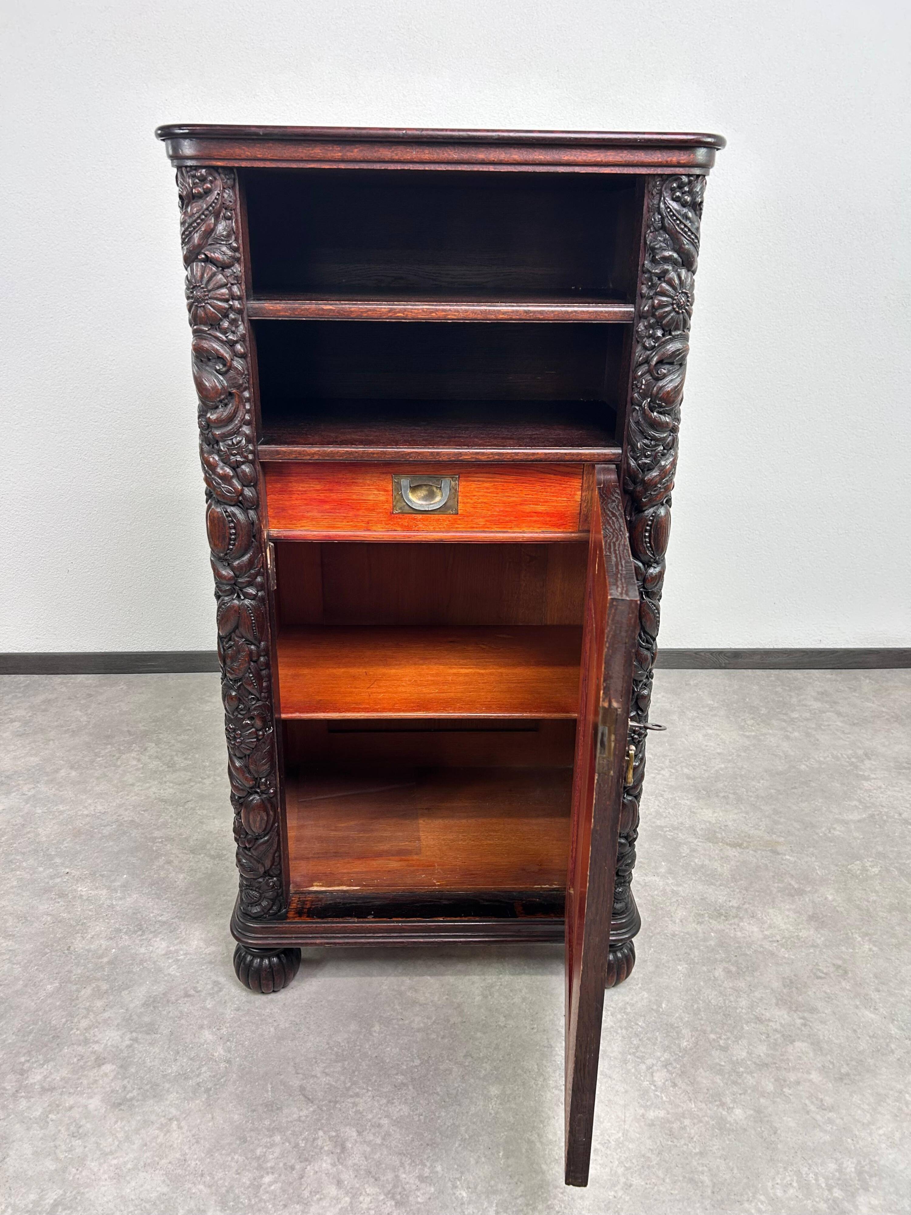 Art Nouveau cabinet with a shelf featuring distinctive floral sculptures.
