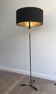 Designer floor lamp in black lacquered metal and brass