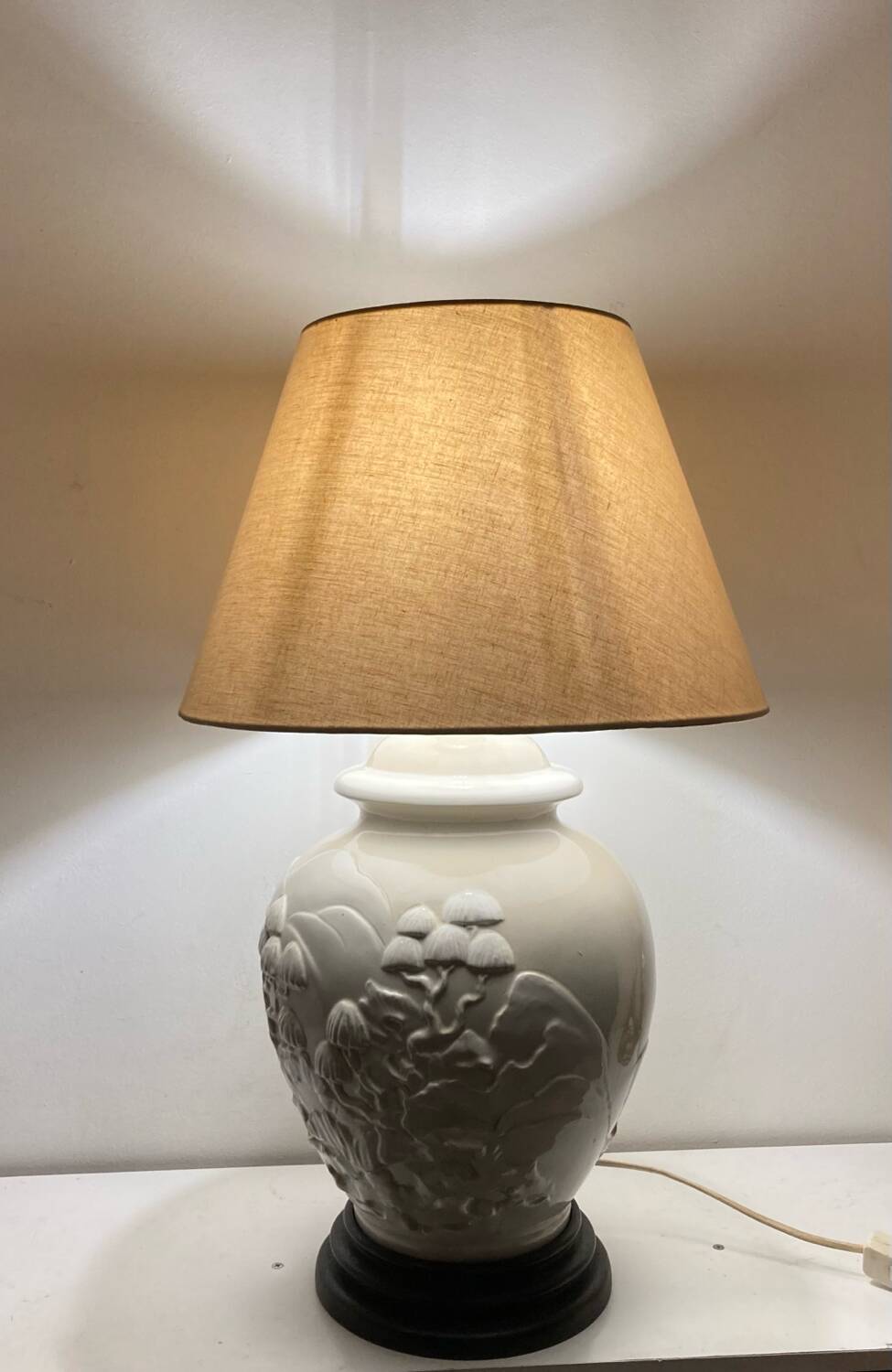 1980s ceramic table lamp with a wooden base and adjustable shade.