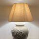 1980s ceramic table lamp with a wooden base and adjustable shade.