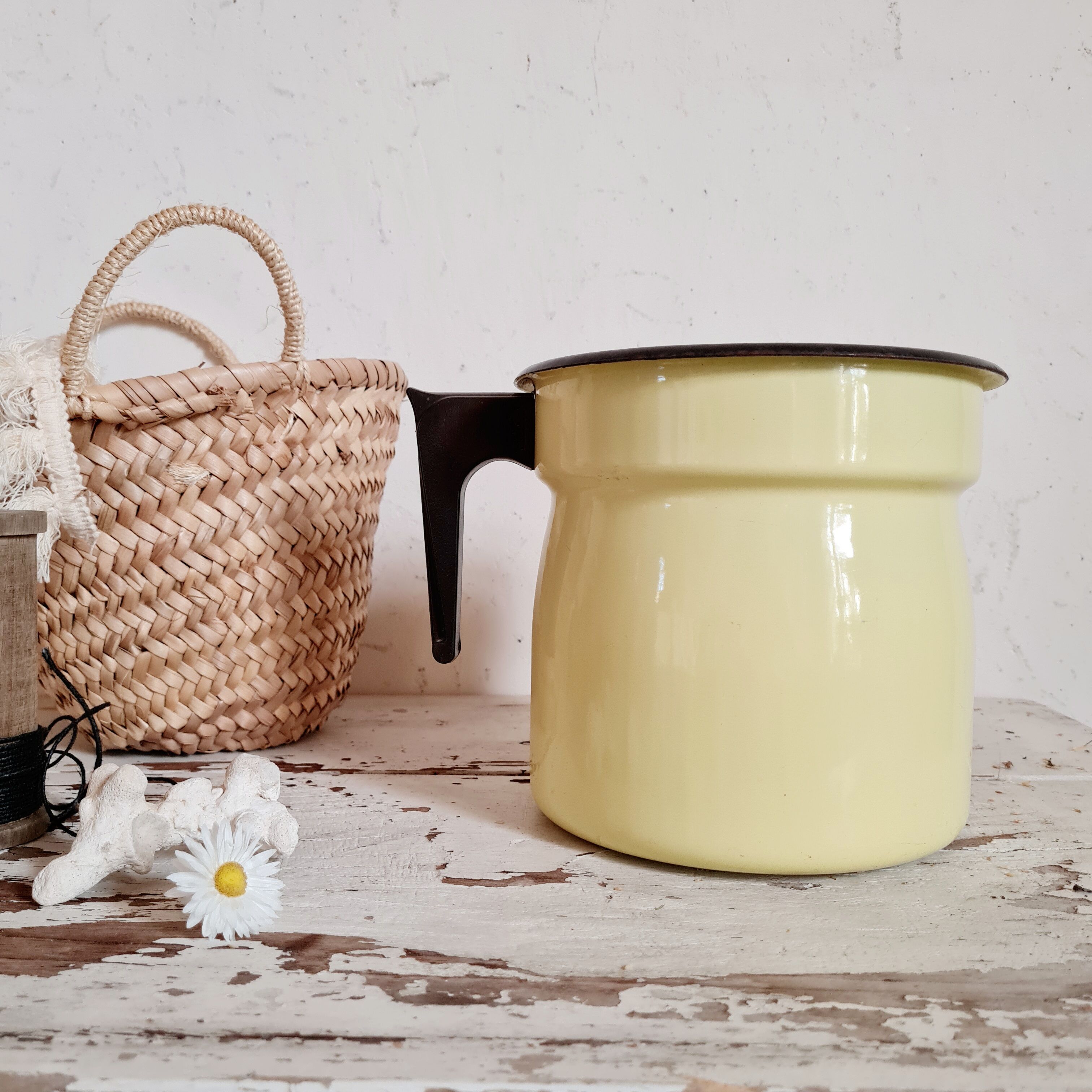 Old pitcher in yellow enamelled sheet metal