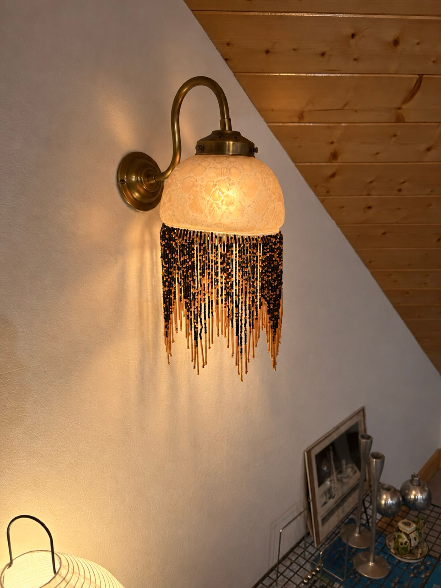 Wall lamp with marbled glass shade and beaded fringe in Art Nouveau style.