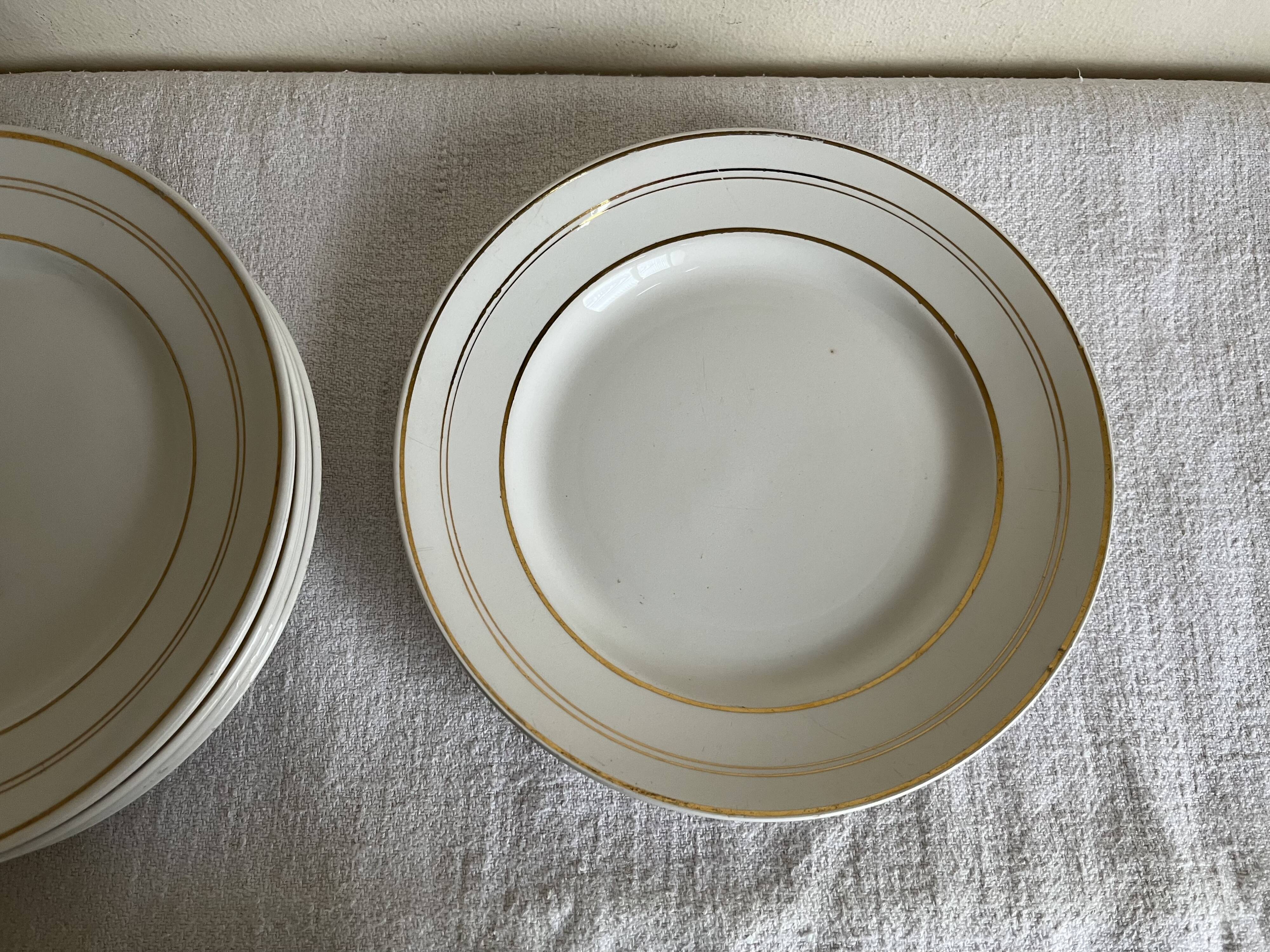 Set of 8 modernist flat plates in fine earthenware with pure gold trim, 1930.
