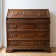 Antique wooden secretary with a drop-down front and drawers.